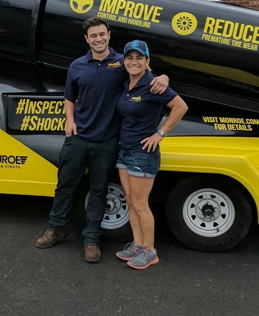 Team members standing beside a Monroe trailer at an event