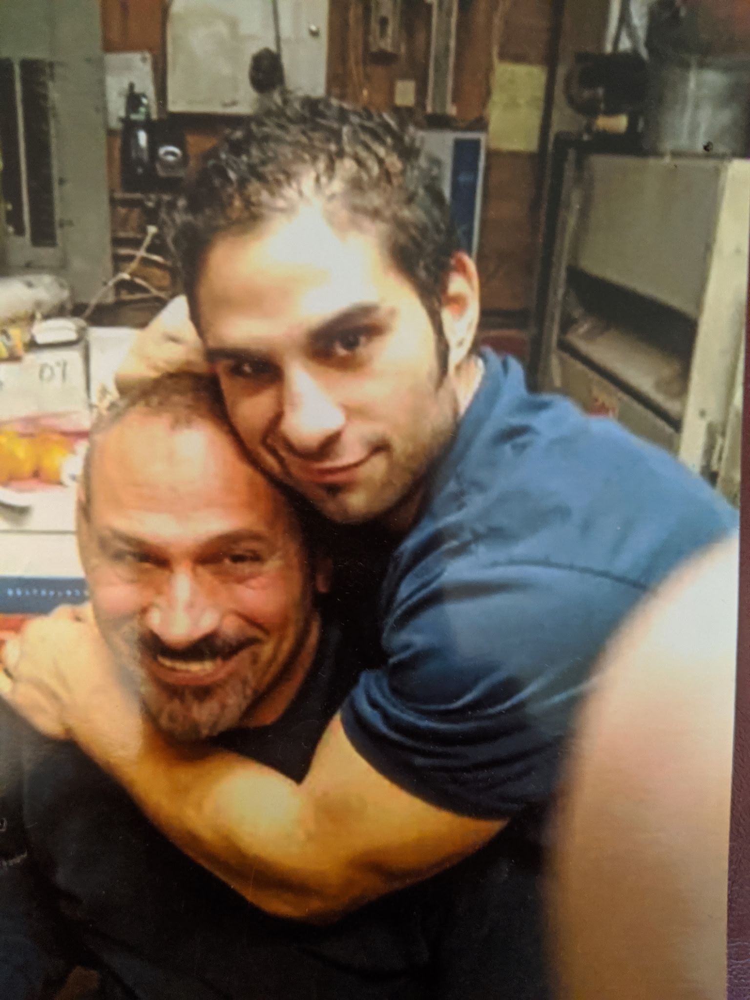 Two family members sharing a hug in the shop office