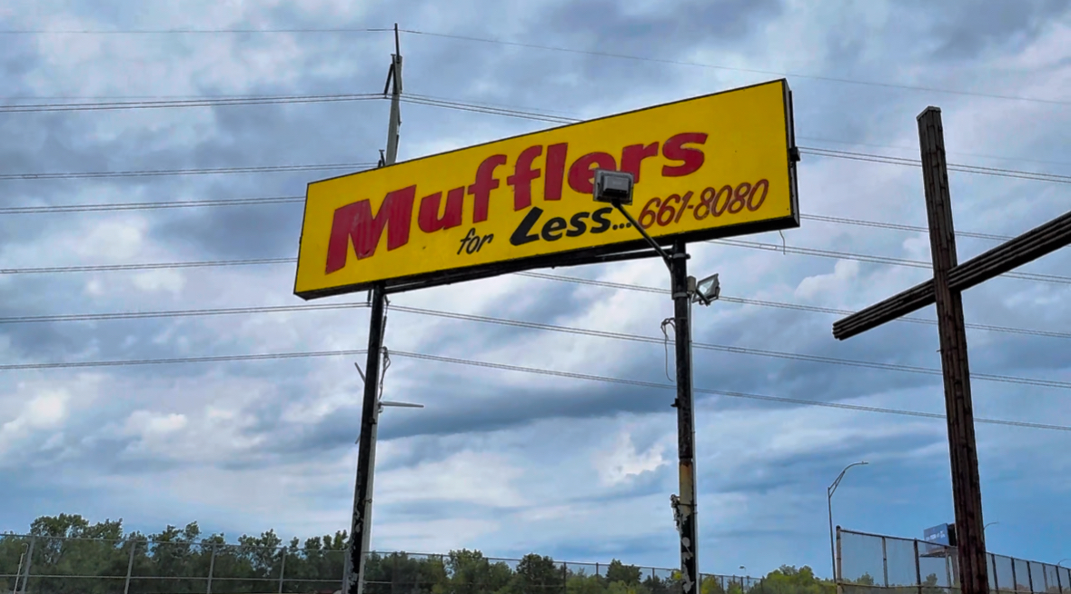 Mufflers For Less sign and cross