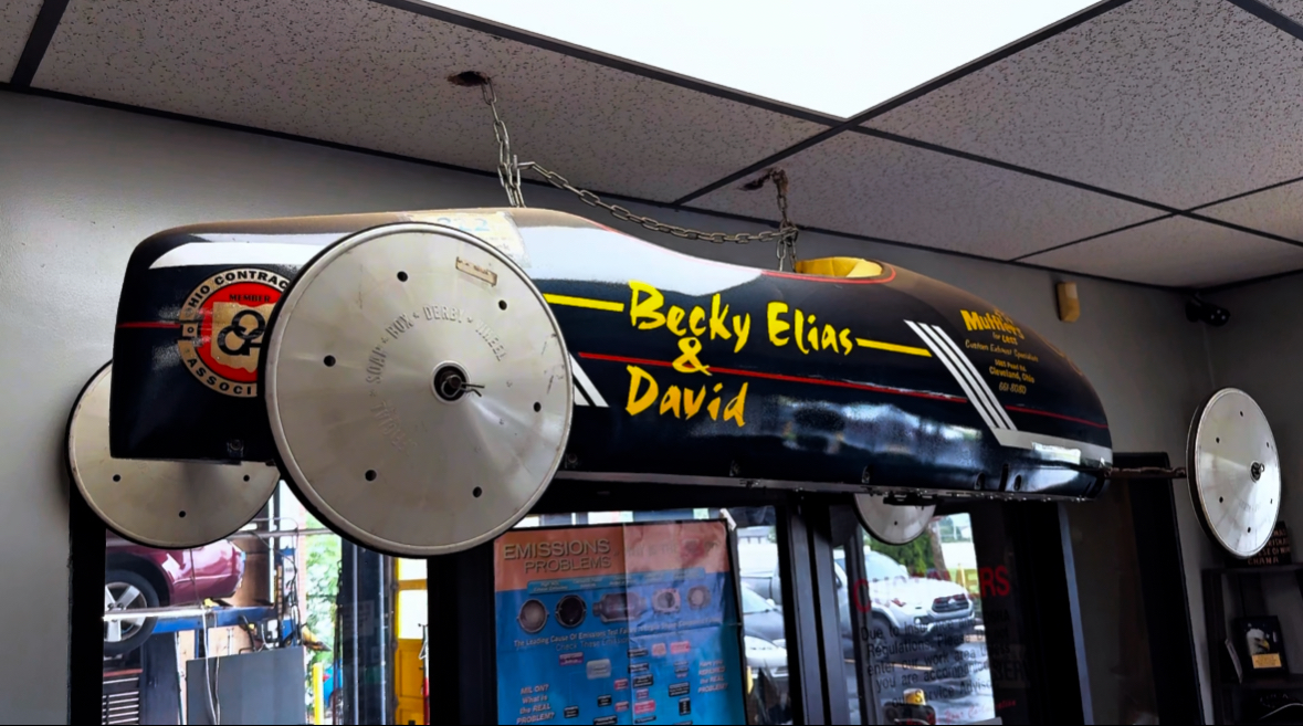 Becky Elias & David soapbox car hanging in shop