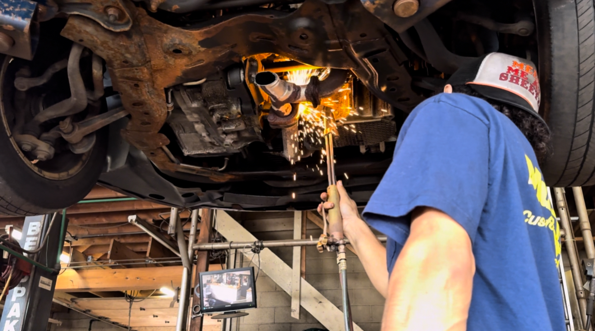 Technician fabricating exhaust with sparks